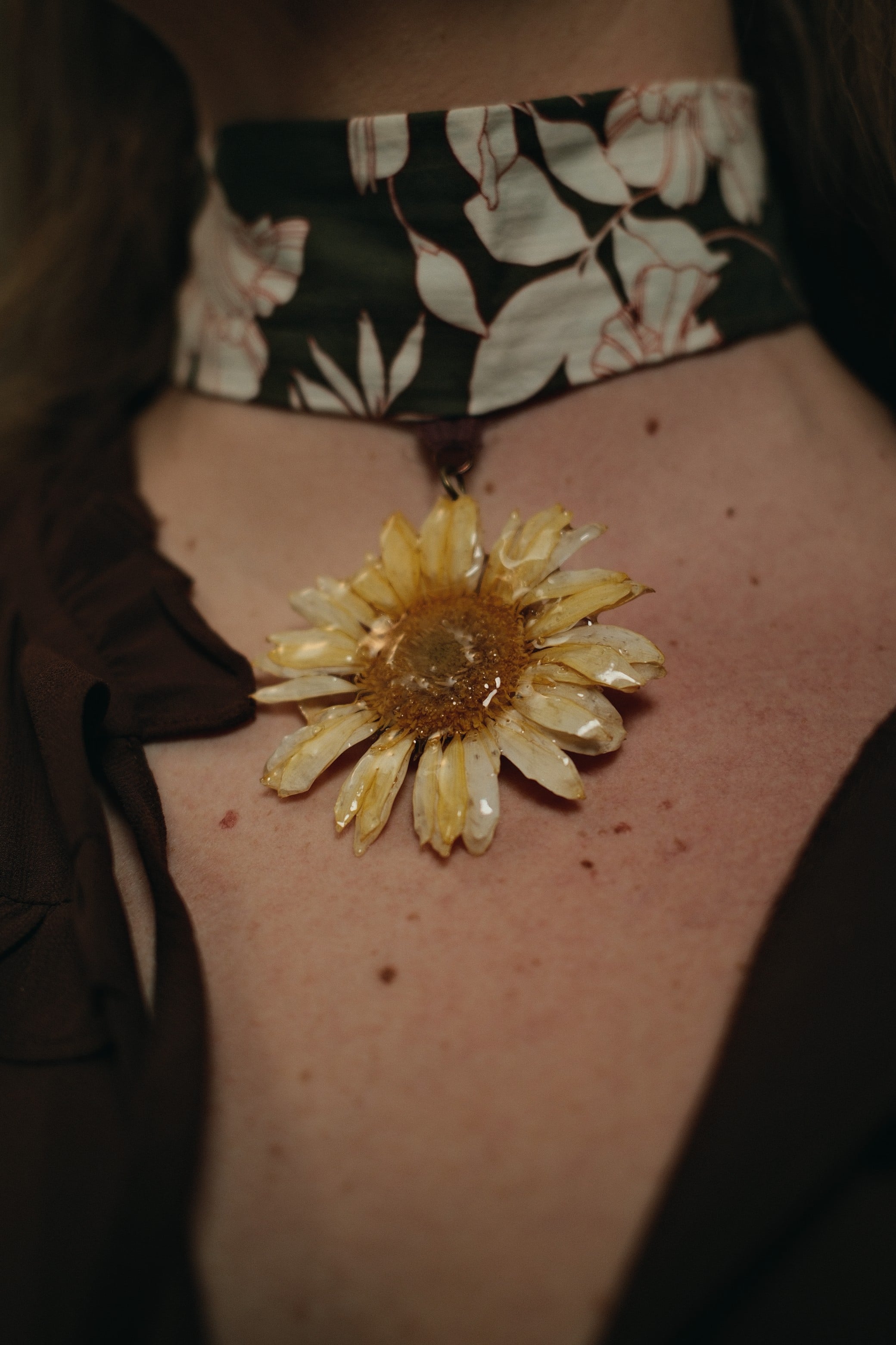 yellow gerbara flower on a green floral choker