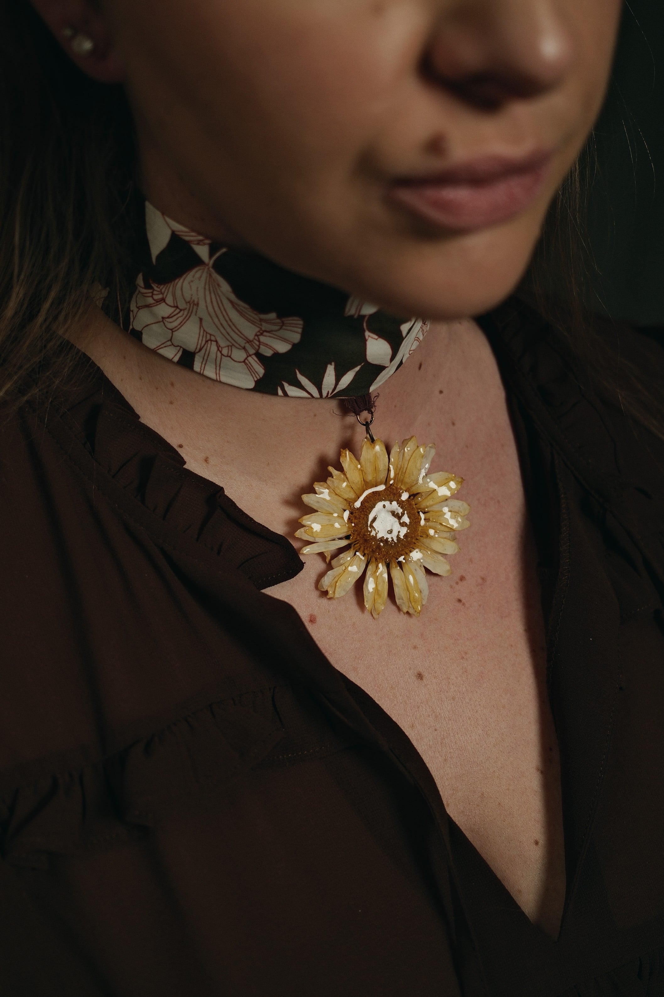 yellow gerbara flower on a green floral choker